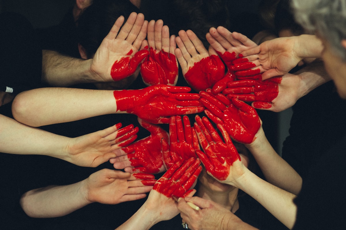 Des mains entrelacées avec un cœur peint, symbole d'engagement solidaire